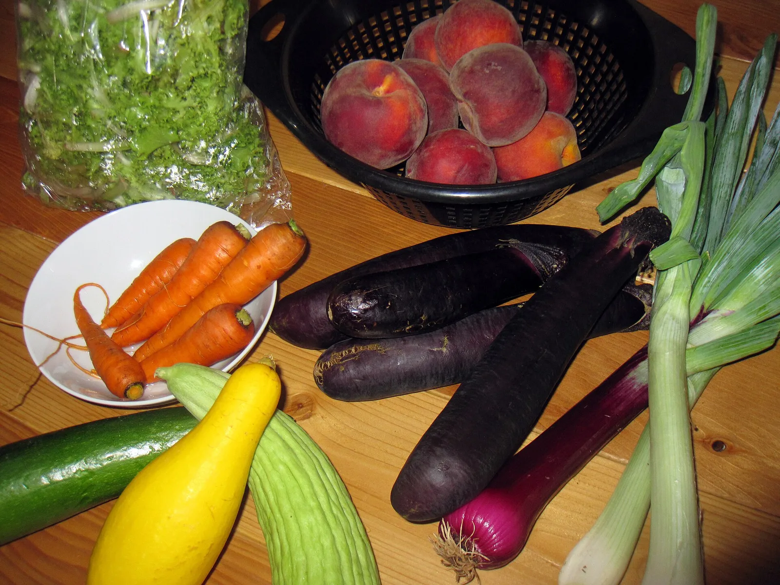 Tomatoes, peppers and other summer produce piled on a farmers market table.