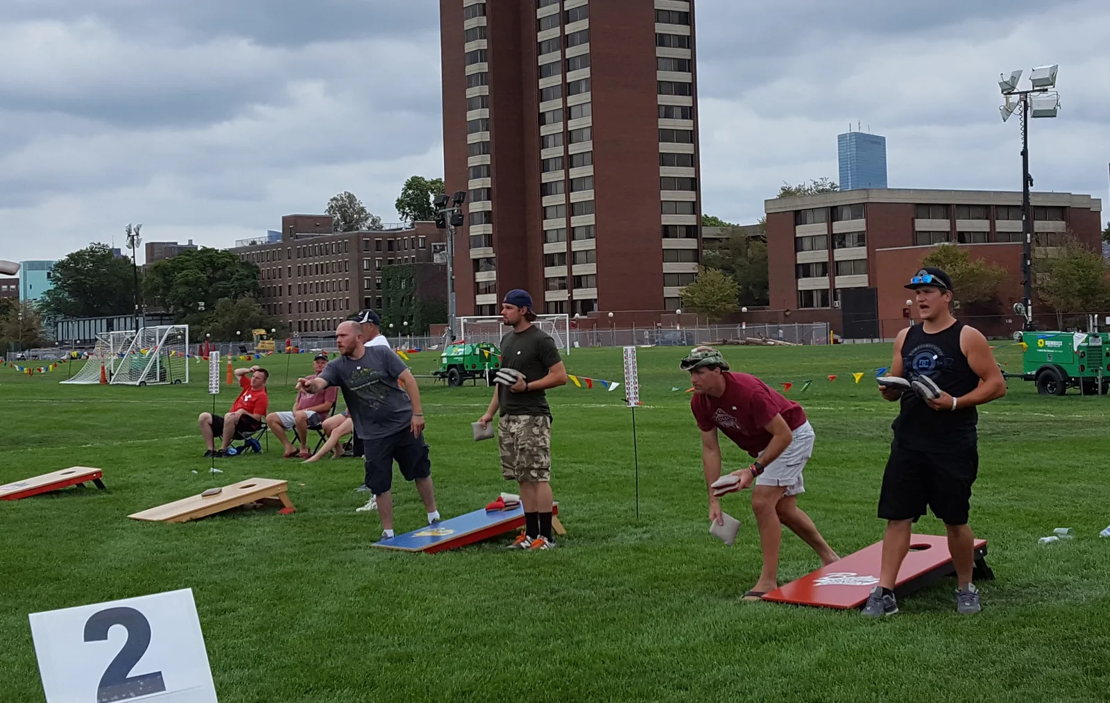 Players toss bean bags at a cornhole tournament.