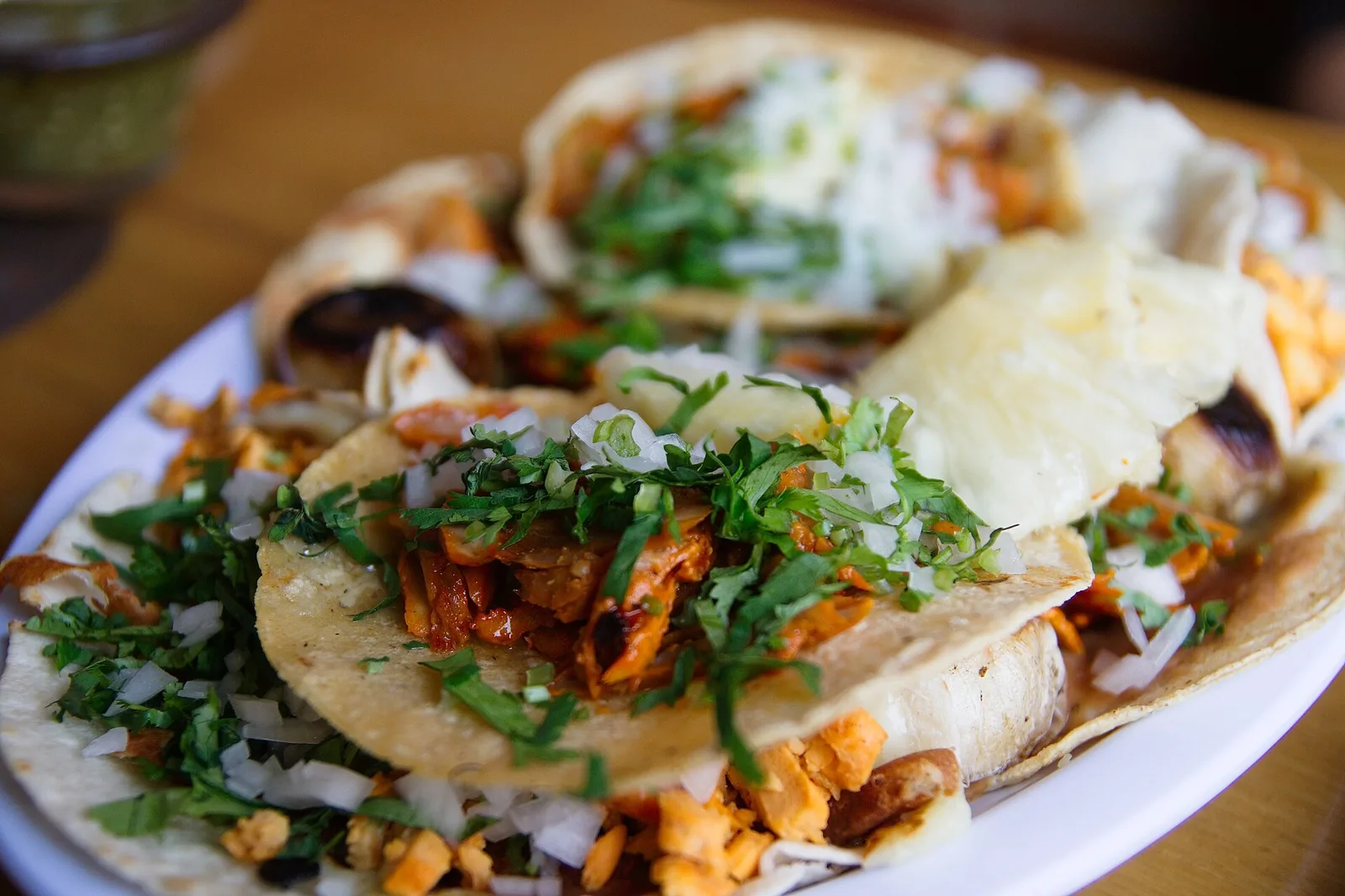 A plate of tacos al pastor with onion, cilantro and lime.