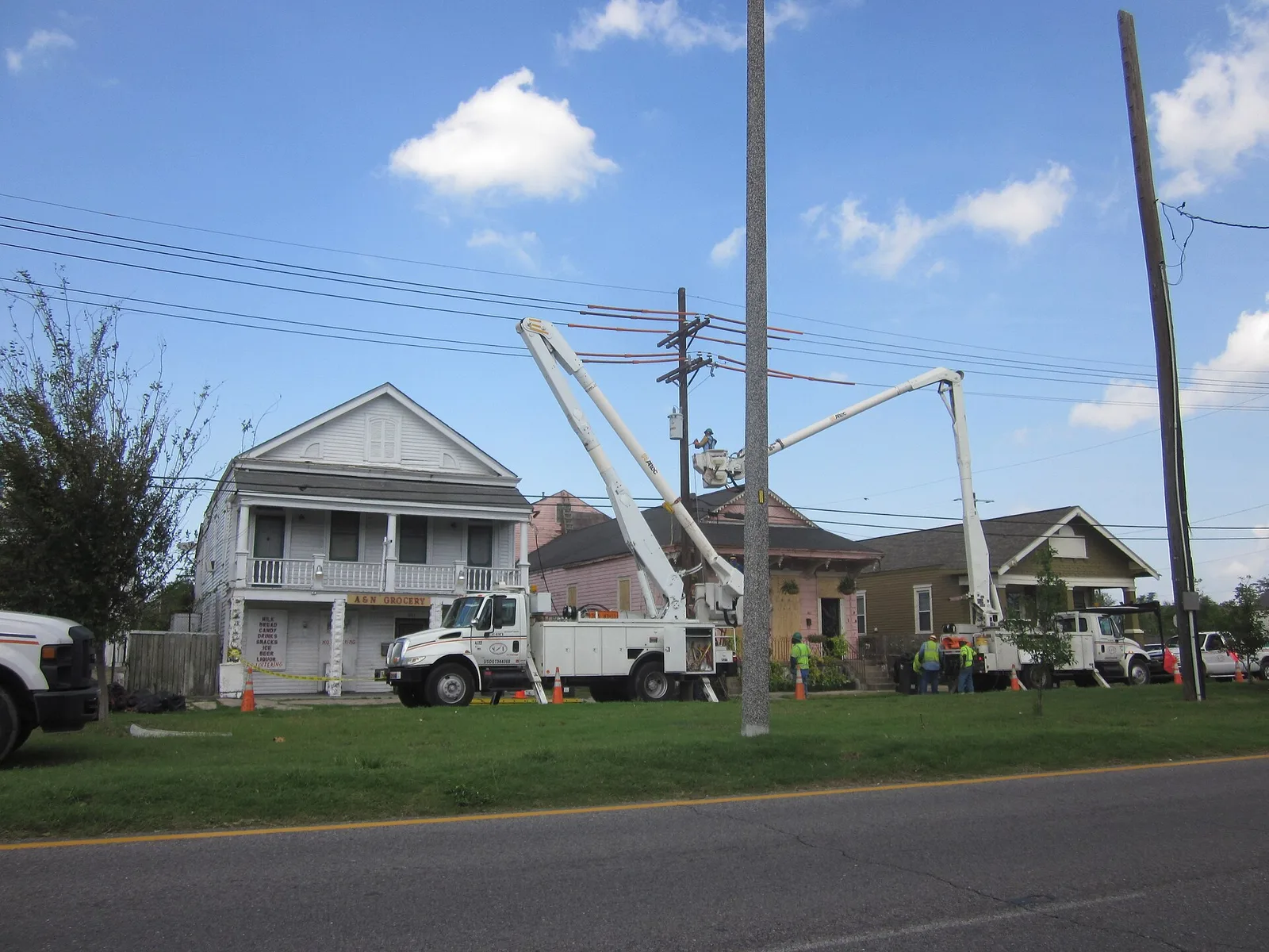 Line workers in bucket trucks restore power lines after a hurricane in New Orleans.