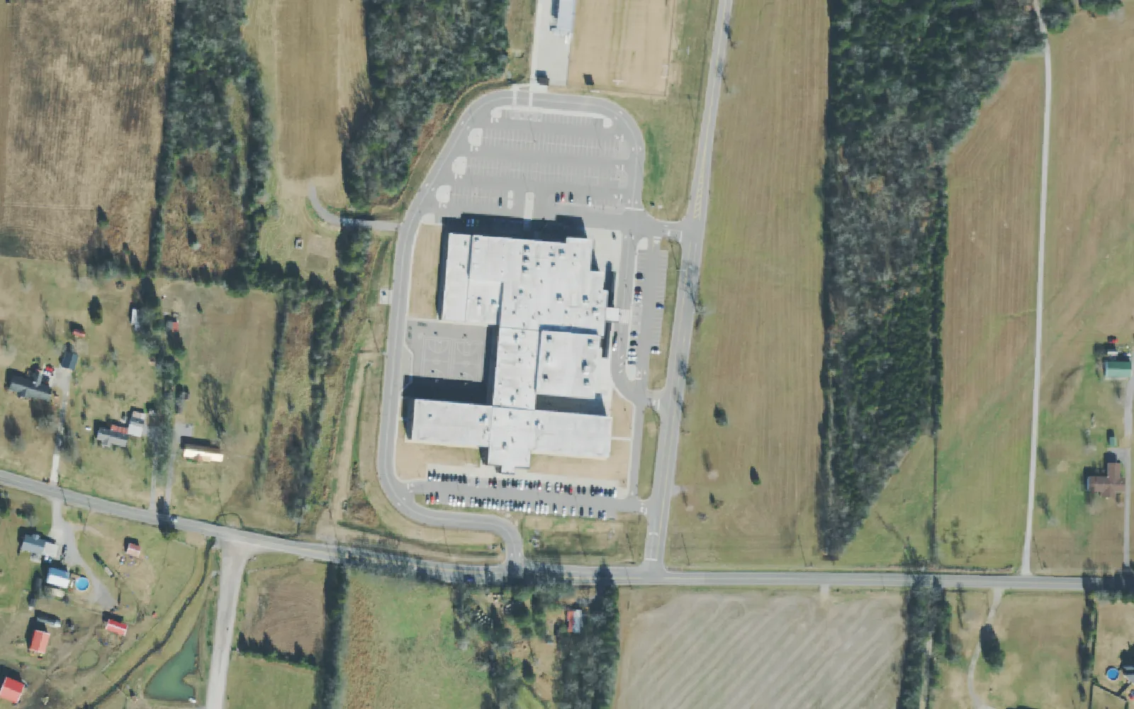 Gladeville Middle School's building and parking lots among farm fields on Stewarts Ferry Pike, seen from the air.