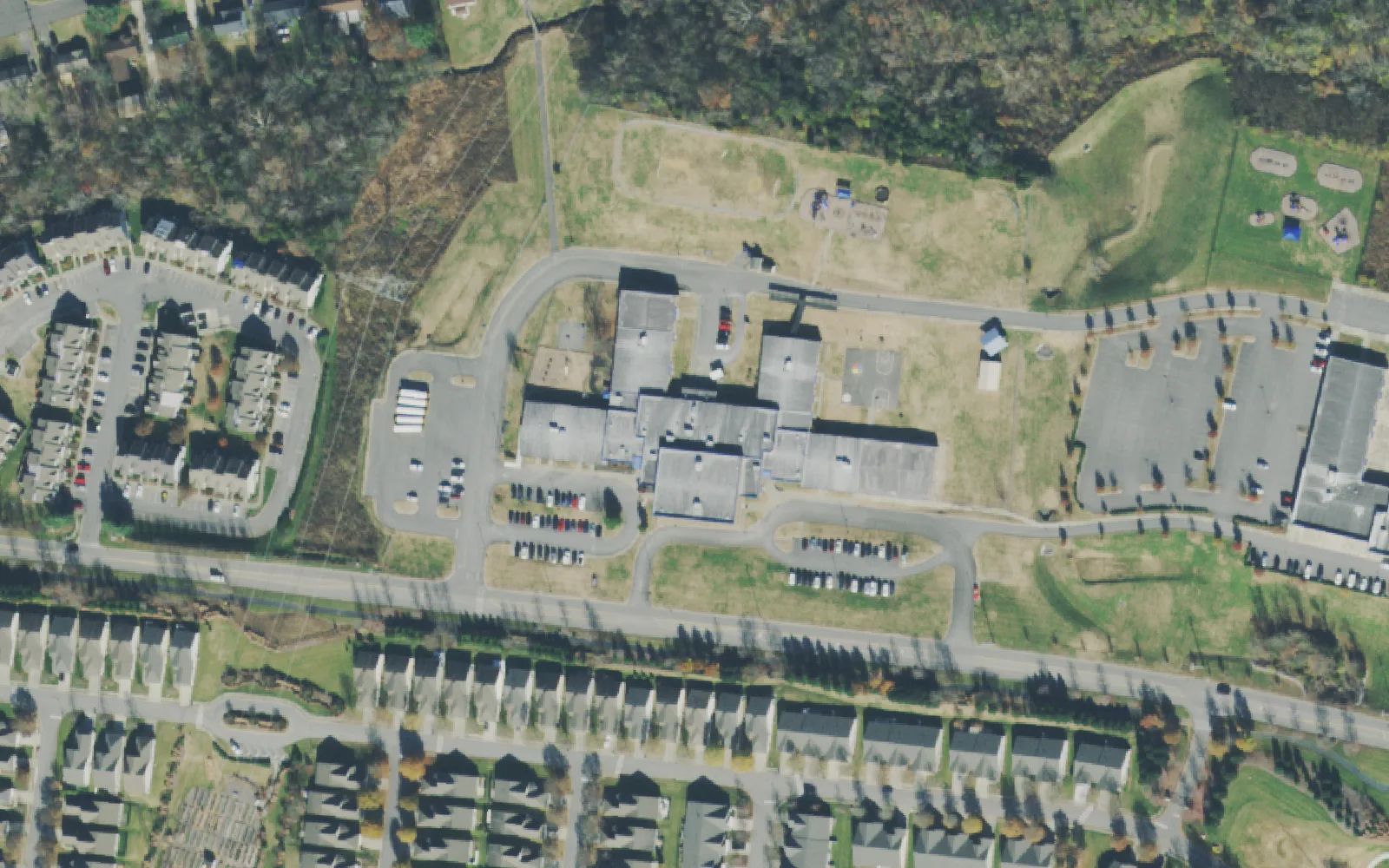 Rutland Elementary School's buildings, playground and parking lots on South Rutland Road in Mount Juliet, with townhomes across the street, seen from the air.