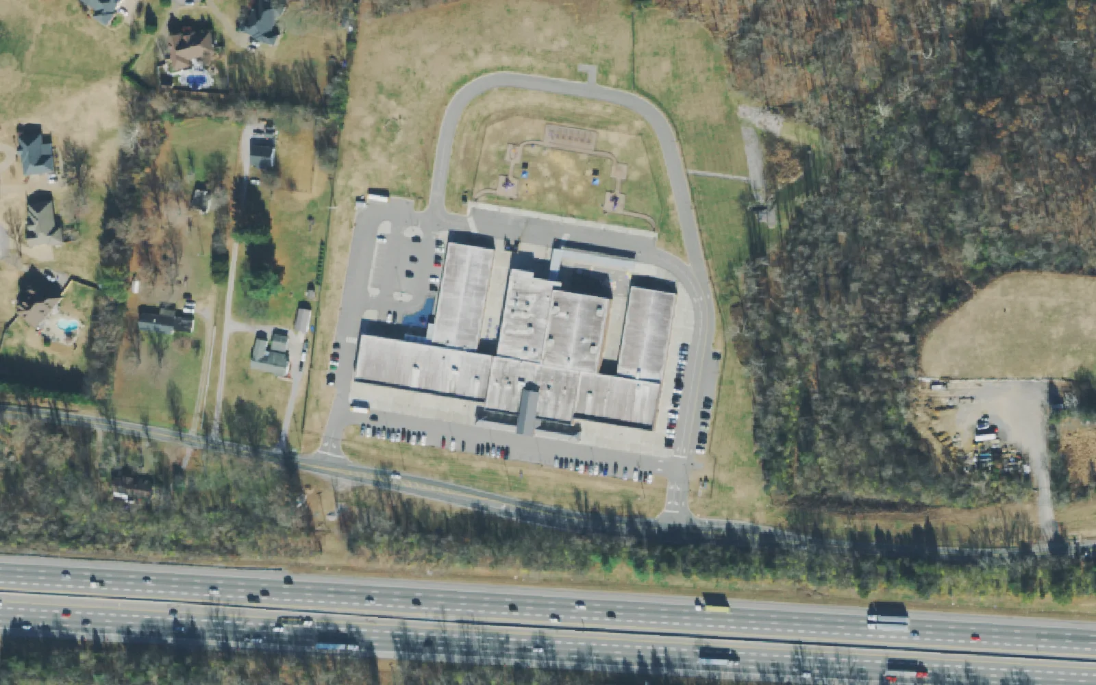 Springdale Elementary School's building and bus loop on Central Pike, with Interstate 40 along the bottom of the frame, seen from the air.