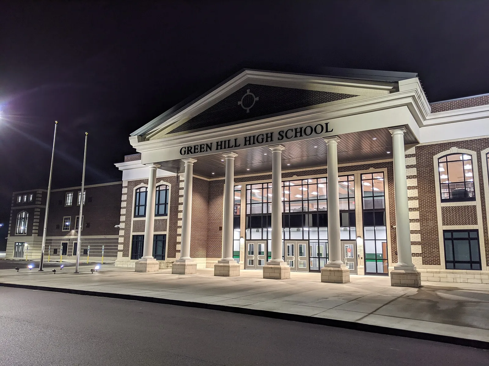 The columned main entrance of Green Hill High School in Mount Juliet, lit up at night.