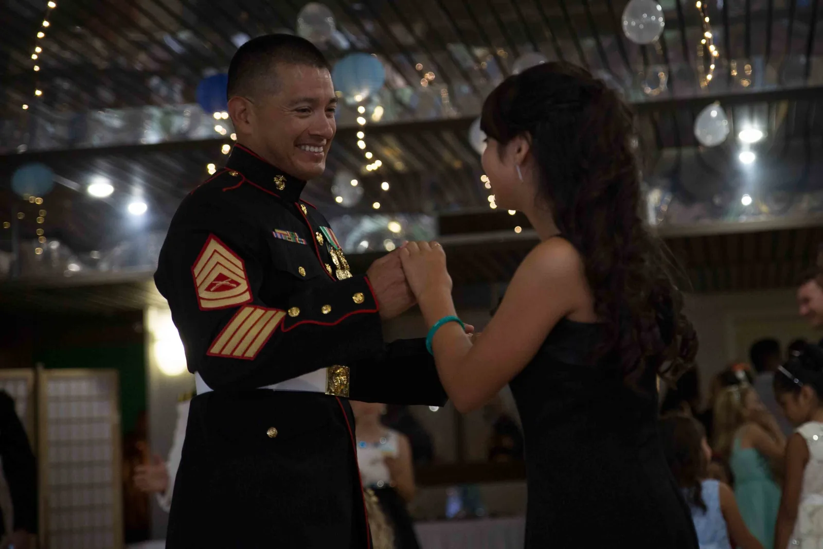 Fathers and daughters dance together at a father-daughter dance.