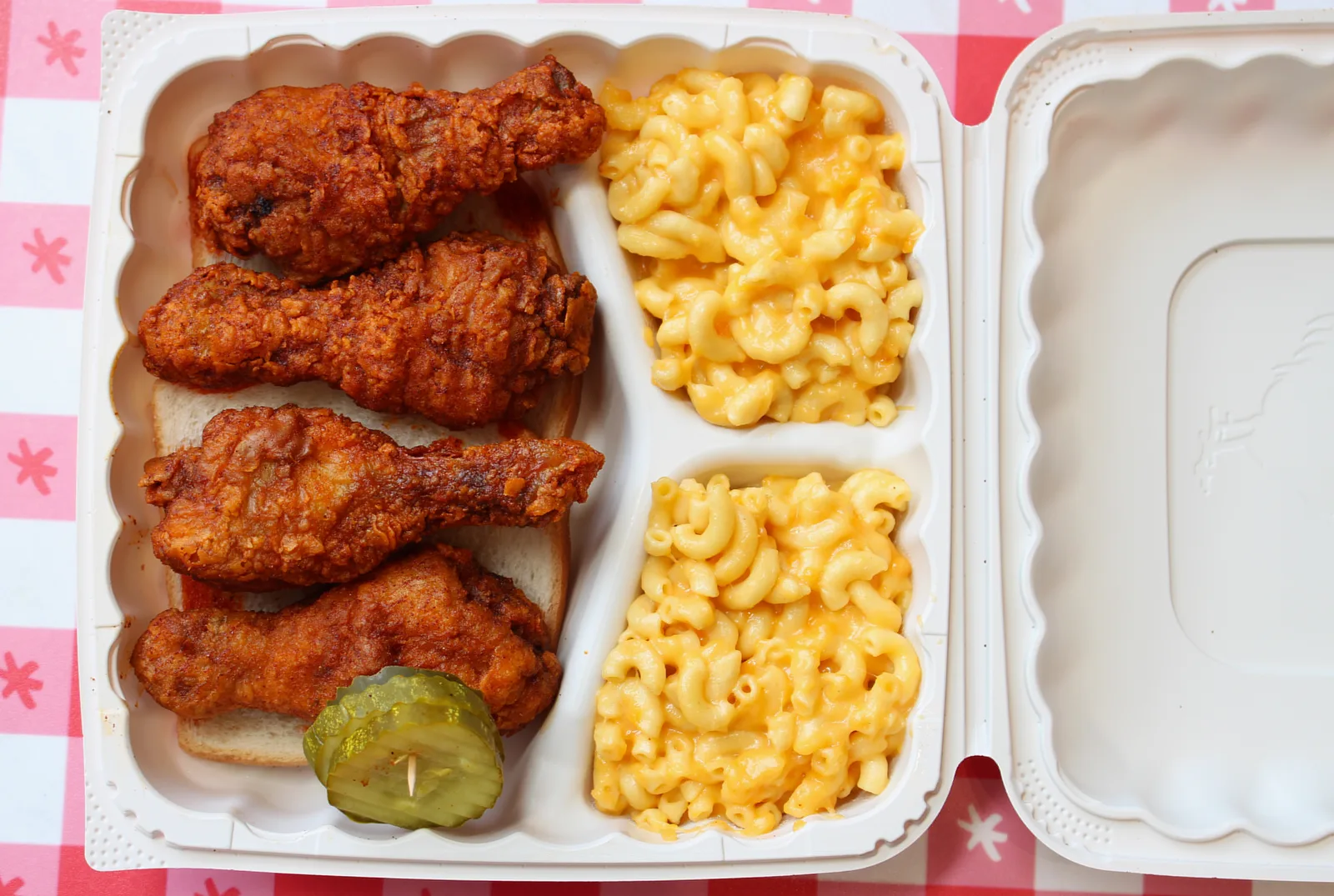Nashville-style hot chicken drumsticks on white bread with macaroni and cheese.